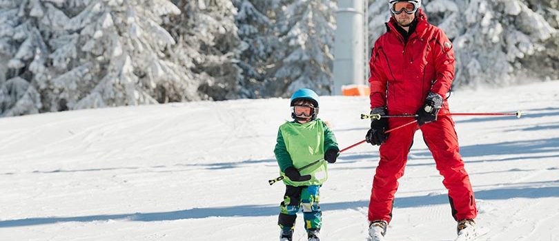 Ski instructor learning little boy skiing